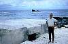 Ken Colling at Wake Island while on the way home with Article 131. In the background is a Japanese pillbox and a sunken ship