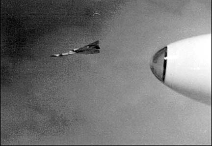 Seconds after the midair collision of Joe Walker's F-104N and Al White and Carl Cross's XB-70A. The badly damaged XB-70 has become inverted and starting to sprial towards the ground below. Note how the other planes have broken formation and distanced themselves from the debris.